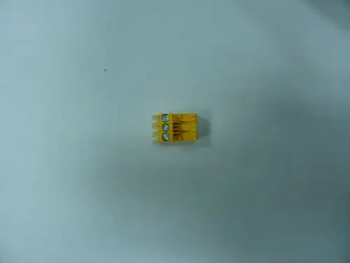 Gelber Stecker mit zwei Schrauben und drei Anschlussklemmen, möglicherweise von Remeha, auf hellem Hintergrund abgebildet.